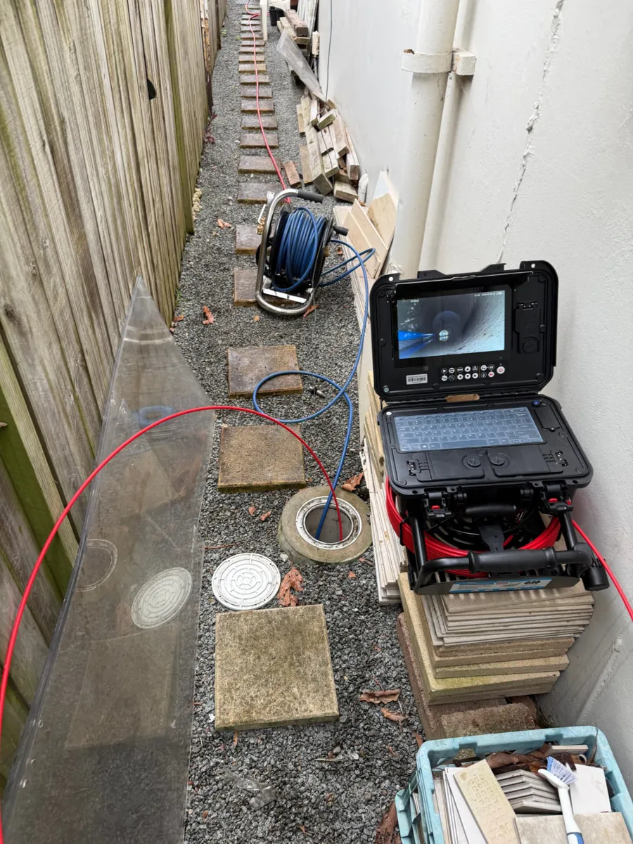 CCTV drain camera and cable reels inspecting a drain beside a Sydney home