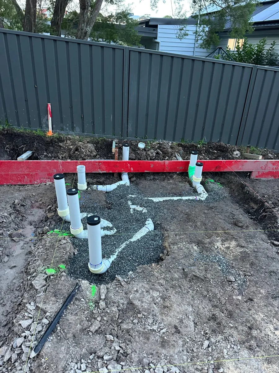 PVC sewer drainage rough-in installed in gravel for a new build